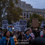 A large group of protesters hold signs reading “DEFEND DEMOCRACY: IT’S TIME FOR A GENERAL STRIKE” and “ICE OUT OF NYC NOW” during the ICE OUT of NYC protest at Foley Square on October 22, 2025.