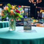 Vase of colorful flowers and a “Donate to CHiPS!” sign on a green tablecloth at the CHiPS Annual Gala 2025 in 501 Union, Brooklyn.