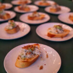Close-up of plated crostini appetizers topped with a creamy crab salad and garnish, served at the 2025 CHiPS Annual Gala in Park Slope.
