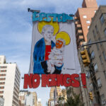 Hand-painted protest banner showing Jeffrey Epstein holding a baby resembling Donald Trump with the words “FOR THE EPSTEIN THRONE” and “NO KINGS!” held up during the No Kings March in New York City.