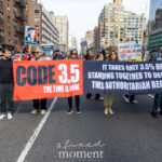 Protesters march in New York City holding a large red and black banner reading “CODE 3.5 — THE TIME IS NOW” and “It takes only 3.5% of us standing together to defeat this authoritarian regime.”