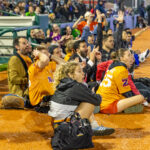 Queens team players and spectators gasp and cheer while watching a critical play during “The Cost of Living Classic” soccer tournament at Maimonides Park in Coney Island.