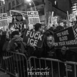 Protesters behind barricades hold signs that say “FUCK ICE,” “YOU HAVE BLOOD ON YOUR HANDS,” and “THEY MADE A FASCIST OUT OF YOU” during the ICE OUT of NYC protest in Manhattan on October 22, 2025.