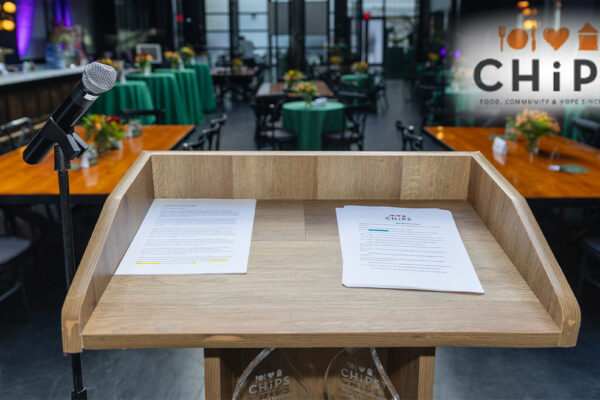 CHiPS Annual Gala Raises Over $160K to Fight Hunger in Brooklyn A wooden podium with a microphone and CHiPS event notes set up at 501 Union in Park Slope, Brooklyn, ahead of the CHiPS Annual Gala celebrating food, friendship, and community.