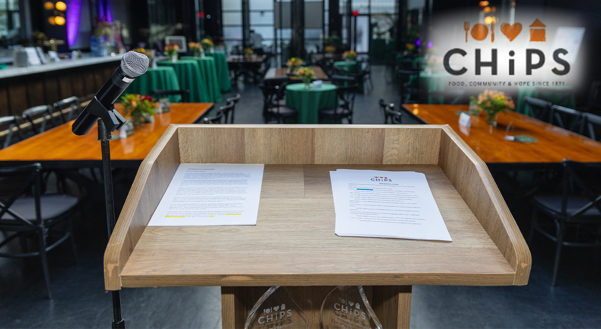 A wooden podium with a microphone and CHiPS event notes set up at 501 Union in Park Slope, Brooklyn, ahead of the CHiPS Annual Gala celebrating food, friendship, and community.