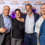 David Costabile stands with three guests in front of the CHiPS step-and-repeat banner at the 2025 Annual Gala in Park Slope, Brooklyn.