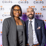 Two guests smiling in front of the CHiPS banner at the 2025 Annual Gala in Park Slope, Brooklyn.