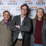 Three men posing in front of the CHiPS banner at the 2025 Annual Gala in Park Slope, Brooklyn.