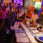 An attendee examines silent auction items at the CHiPS Annual Gala 2025 at 501 Union in Park Slope, Brooklyn.