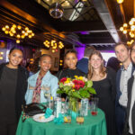 A group of seven guests smiling around a cocktail table at the CHiPS Annual Gala 2025 at 501 Union in Park Slope, Brooklyn.