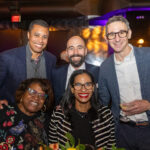 Five smiling guests pose together at the CHiPS Annual Gala 2025 in Brooklyn, dressed in formal and semi-formal attire under warm event lighting.