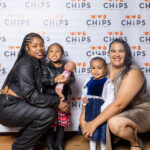Two women and two children smiling and posing in front of a CHiPS logo backdrop at the 2025 CHiPS Annual Gala in Brooklyn.