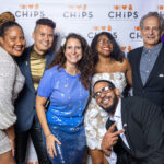 Smiling group of adults and a baby posing together in front of the CHiPS step-and-repeat banner at the 2025 Annual Gala in Park Slope, Brooklyn.