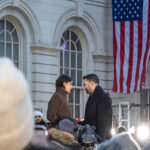 Zohran Mamdani taking the oath of office while facing his wife, Rama Duwaji, on stage outside New York City Hall on January 1, 2026, with an American flag hanging behind them.