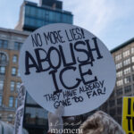 Person holding a round protest sign that reads “No More Lies! Abolish ICE. They Have Already Gone Too Far!” during a winter protest in New York City.