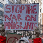 Protest sign reading “Stop the War on Immigrants” held above a crowd during a winter march in New York City.