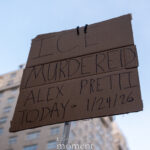 Cardboard protest sign reading “ICE murdered Alex Pretti today 1/24/26” held against the sky at a New York City anti-ICE protest.