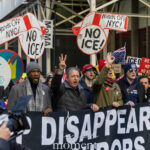 Protesters holding No ICE signs and a Disappearing Neighbors banner during Hands Off protest in New York City.