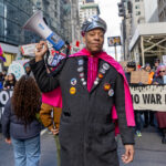 Jay W. Walker holding a megaphone and wearing a pink cape at the Hands Off protest in New York City.