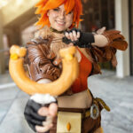 Squirrel Girl cosplay with orange hair, squirrel ears, brown jacket, and slingshot aimed toward camera at Dragon Con 2025 in Atlanta, GA. Cosplayer @river_fish.