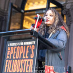 Daphne Rubin-Vega speaks into a microphone at The People’s Filibuster outside The Public Theater in New York City.