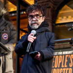 Three speakers at The People's Filibuster event on Public Theater steps including Peter Dinklage and Oscar Isaac speaking at podiums