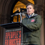 New York State Assembly member Robert C. Carroll speaks at a podium during The People’s Filibuster outside The Public Theater in New York City.