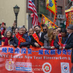 Julie Menin, Brad Hoylman-Sigal, and Mayor Zohran Mamdani stand at the front of the Lunar New Year Parade in Chinatown holding a red banner.