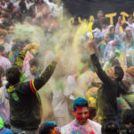 Participants throw yellow colored powder into the air while celebrating Holi at Pier 17 at The Seaport in New York City.