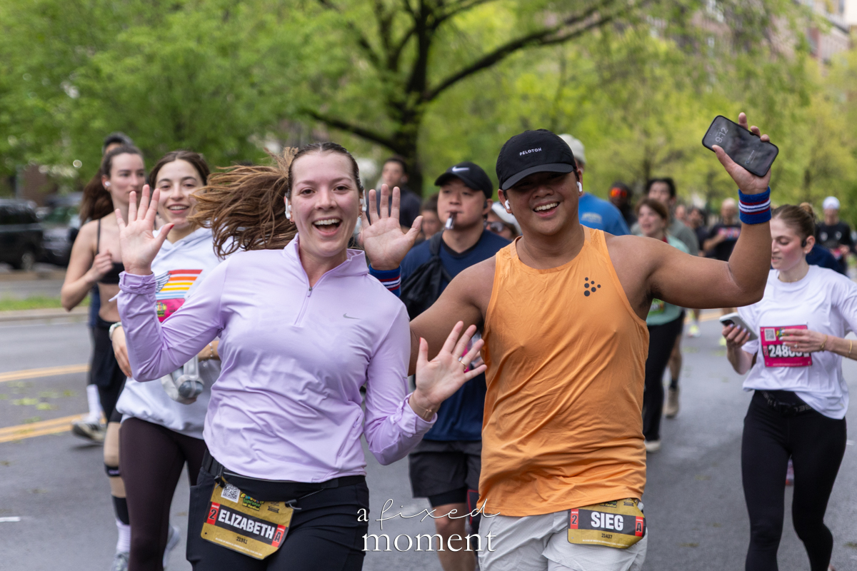 Runners smile and wave mid-race during the Brooklyn Experience Half Marathon