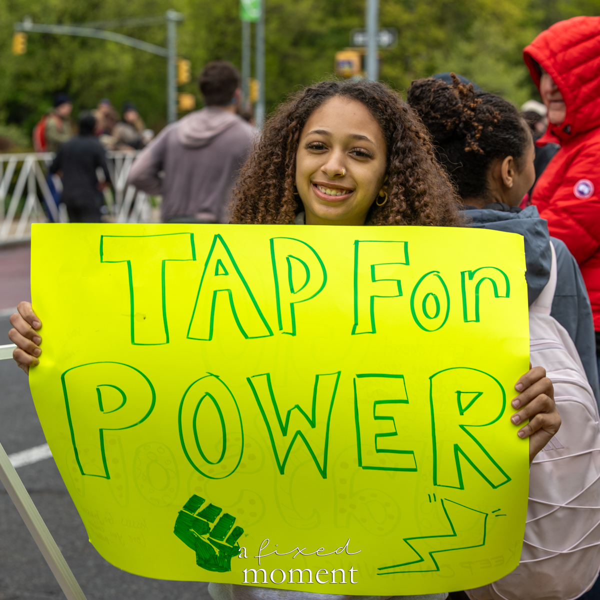Spectator holds a Tap for Power sign