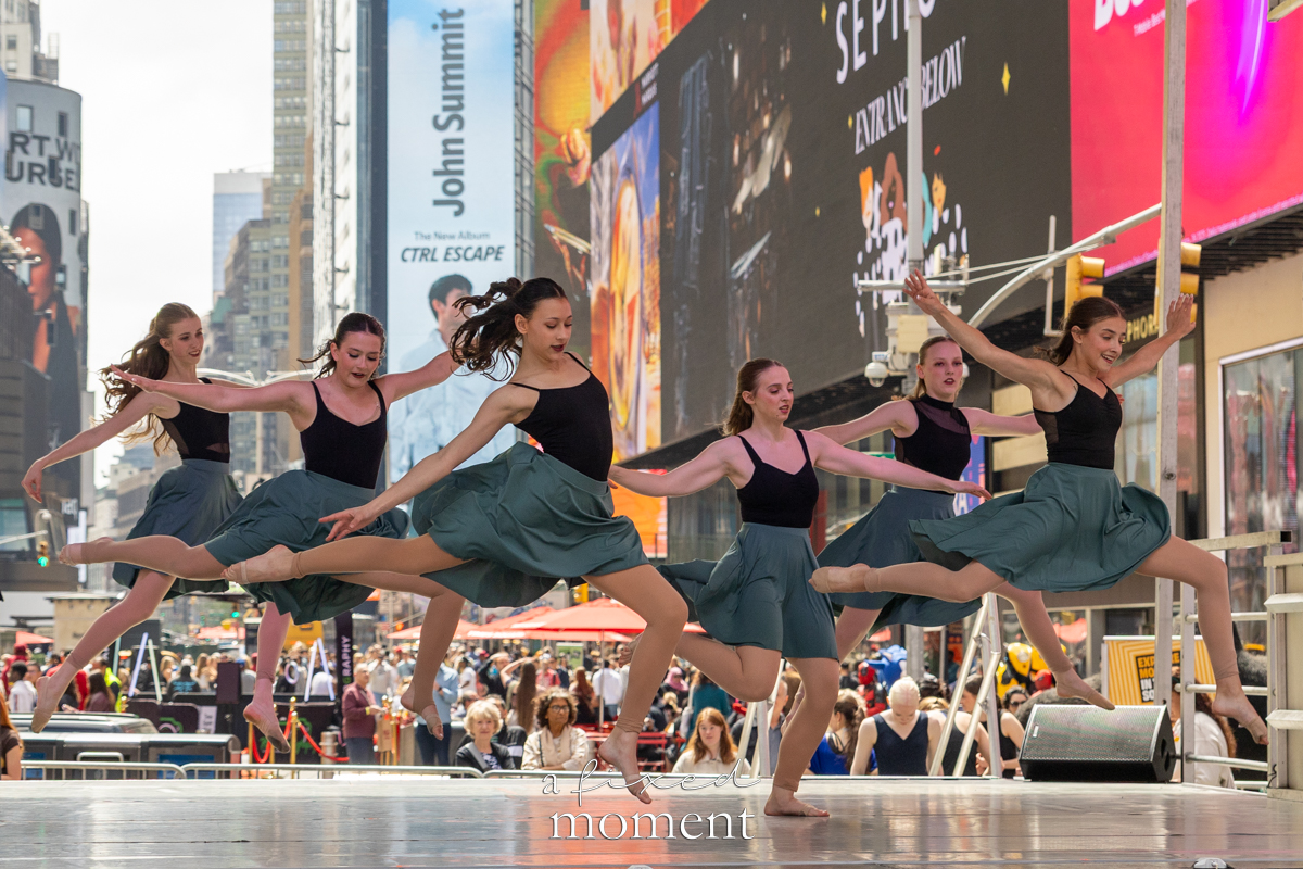 Project Dance ensemble leap in green skirts