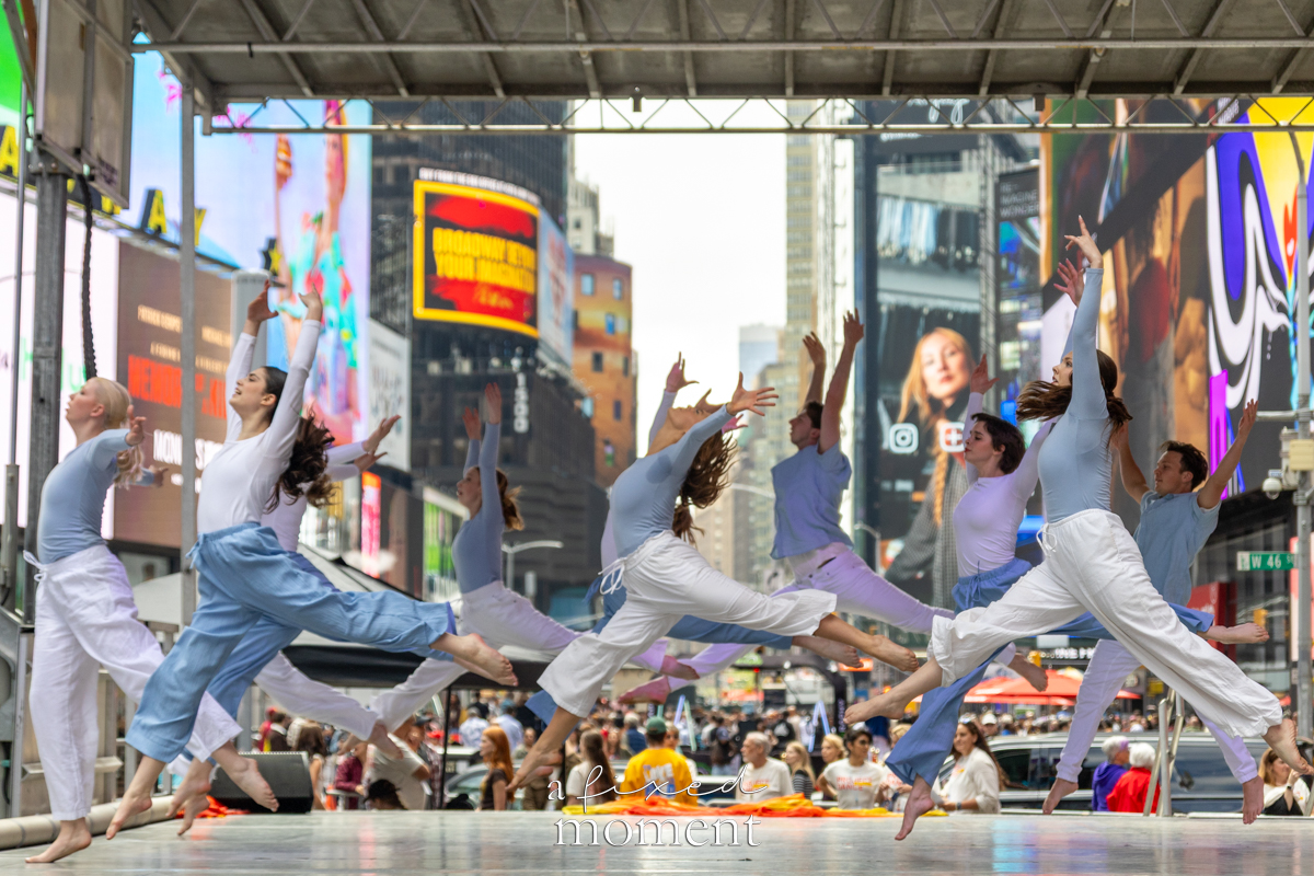 Project Dance ensemble midair leap on stage in Times Square