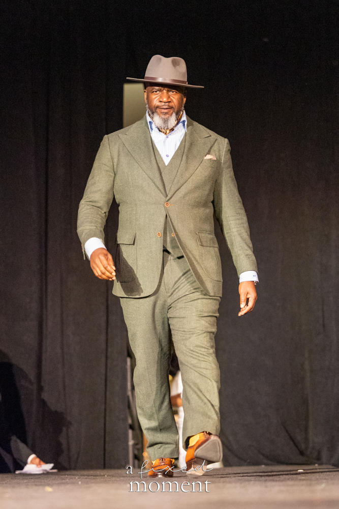 Participant in a green suit and brown hat runway look at Brooklyn's 2026 People's Ball