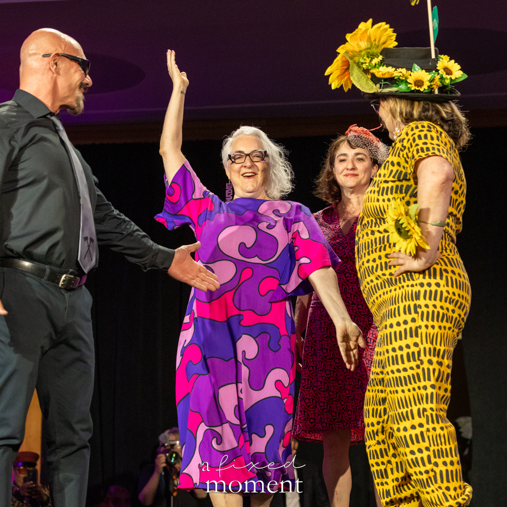 Group of participants wave on the runway, one in a sunflower hat, at Brooklyn's 2026 People's Ball