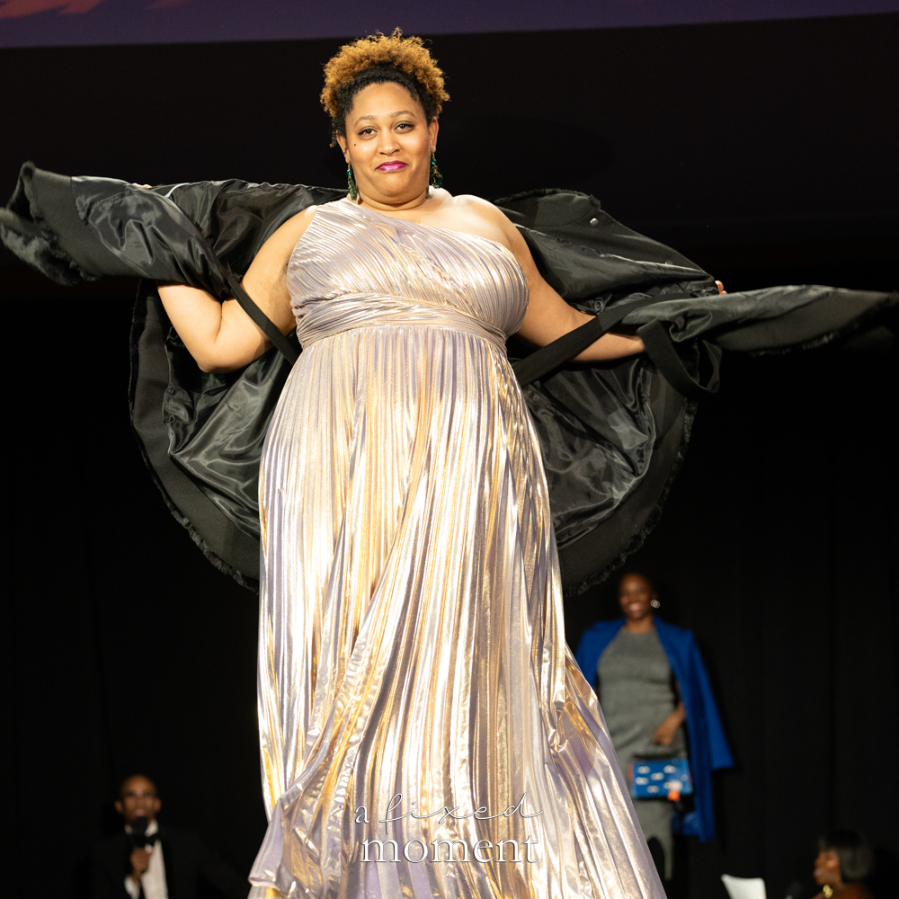 Participant in a metallic dress and black cape runway look at Brooklyn's 2026 People's Ball