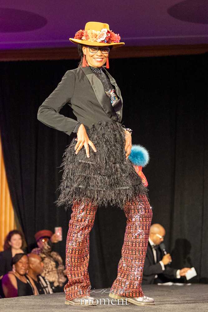 Participant in an orange floral hat and feather skirt on the runway at Brooklyn's 2026 People's Ball