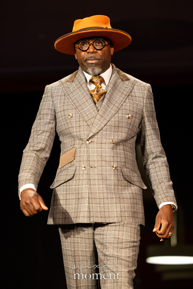 Participant in a plaid suit and orange hat on the runway at Brooklyn's 2026 People's Ball