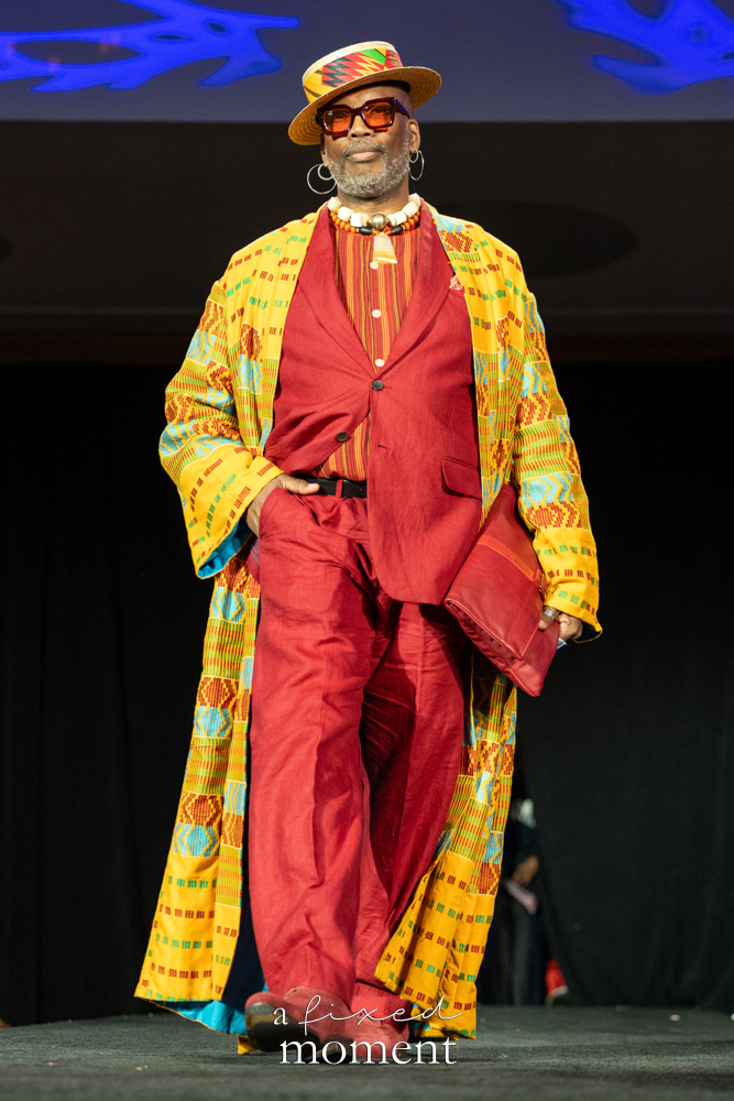 Participant in a red suit and yellow patterned runway look at Brooklyn's 2026 People's Ball