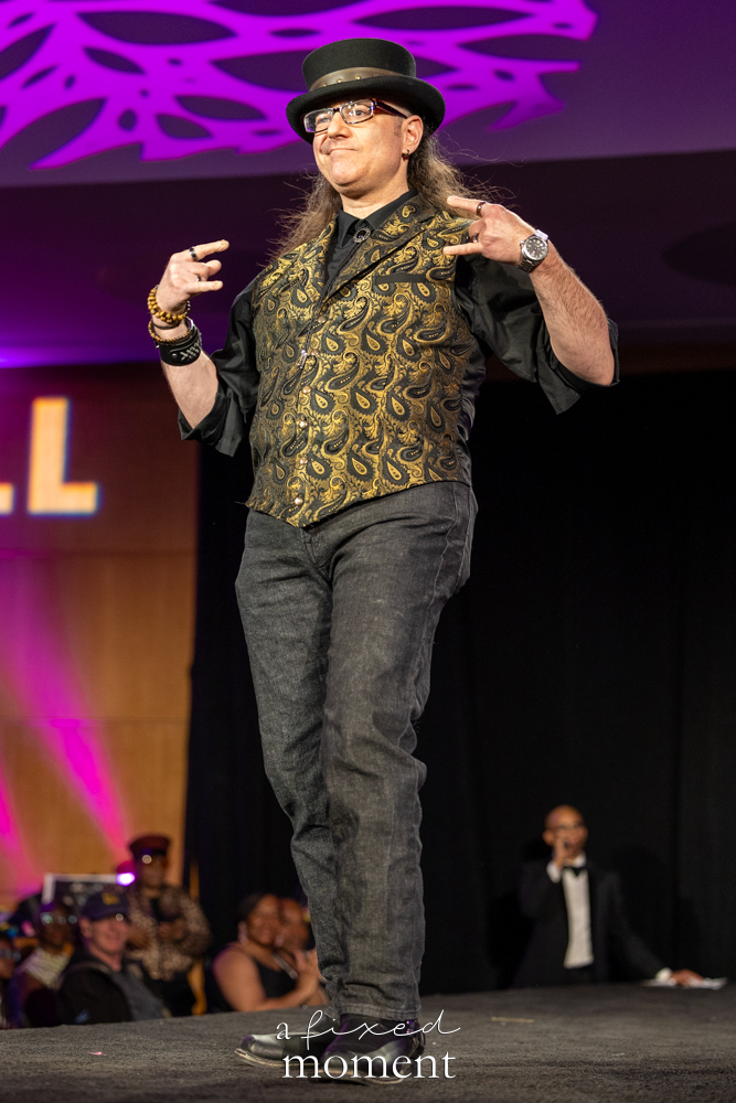 Participant in a top hat and gold paisley runway look at Brooklyn's 2026 People's Ball