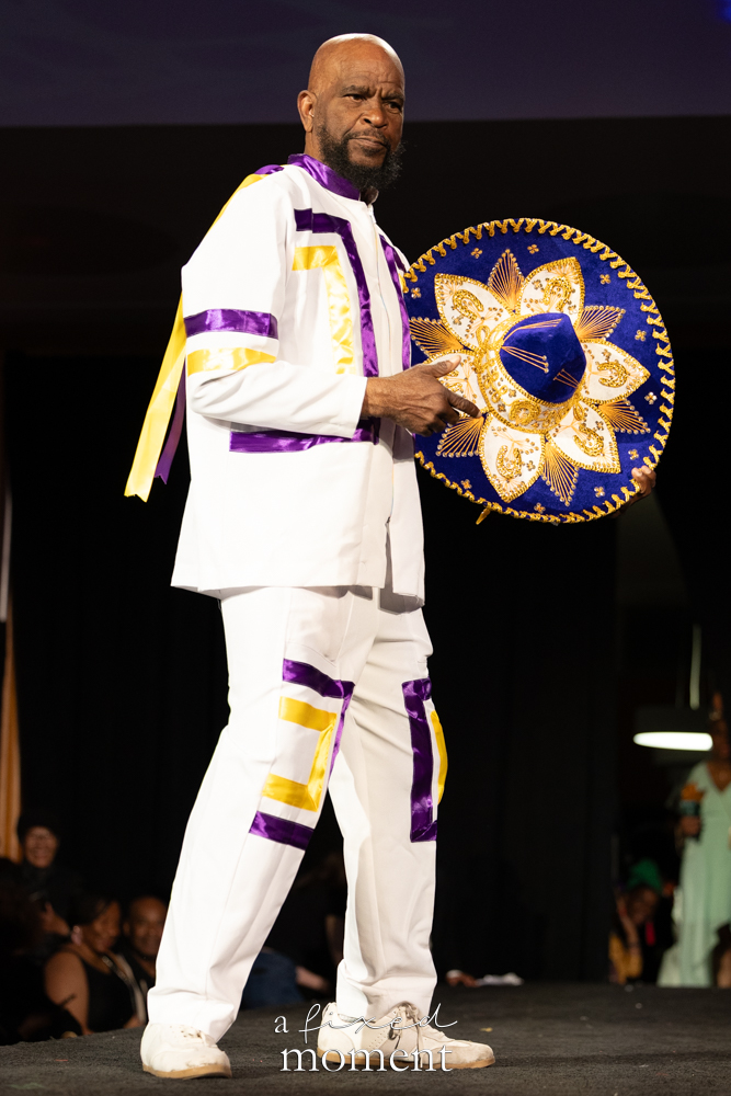 Participant in a white, purple and yellow suit with a sombrero on the runway at Brooklyn's 2026 People's Ball