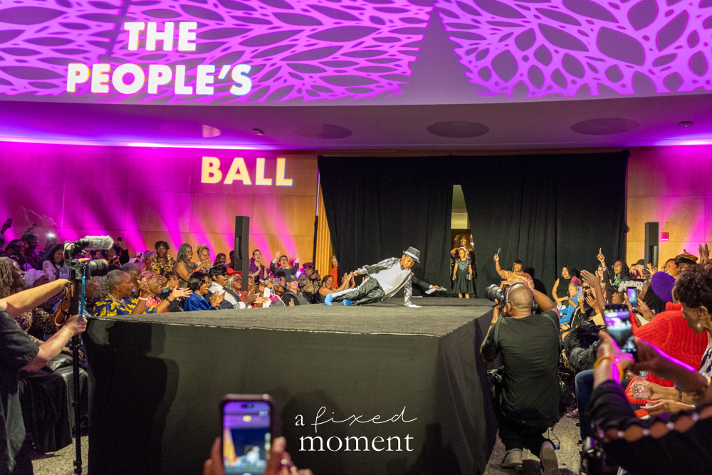 Wide view of Brooklyn's 2026 People's Ball runway with crowd, photographers and The People's Ball projection inside Brooklyn Public Library