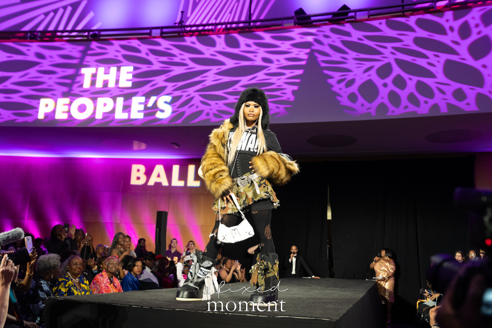 Wide runway view with participant in fur and camouflage layers at Brooklyn's 2026 People's Ball