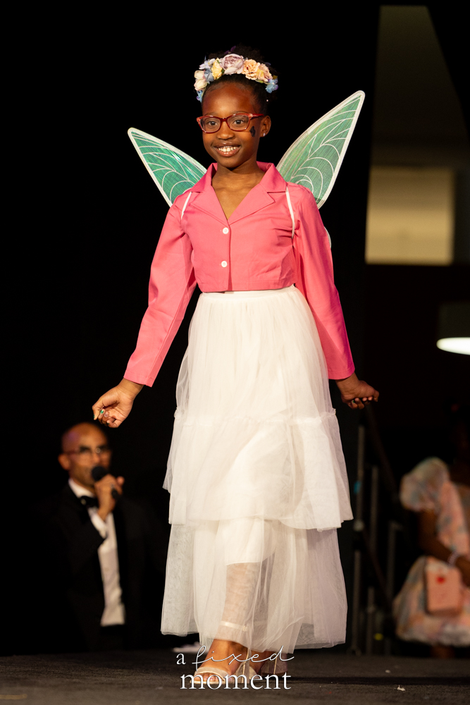 Young participant in fairy wings and a pink jacket on the runway at Brooklyn's 2026 People's Ball
