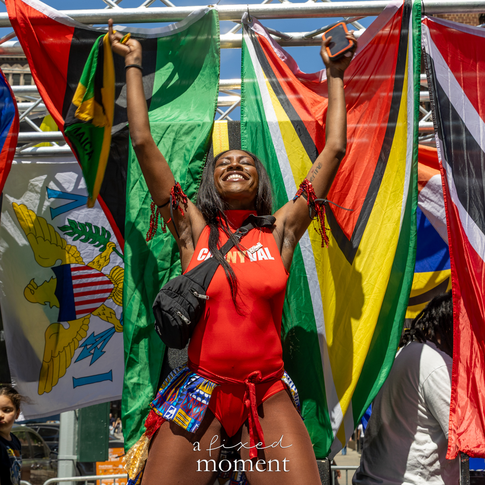 @carnyvaldancers performer waves Caribbean flags during Dance Parade NYC on May 16, 2026