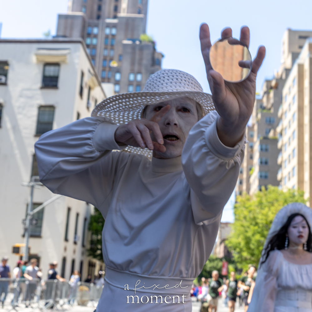 @vangelinebutoh performer in white costume with round prop during Dance Parade NYC 2026