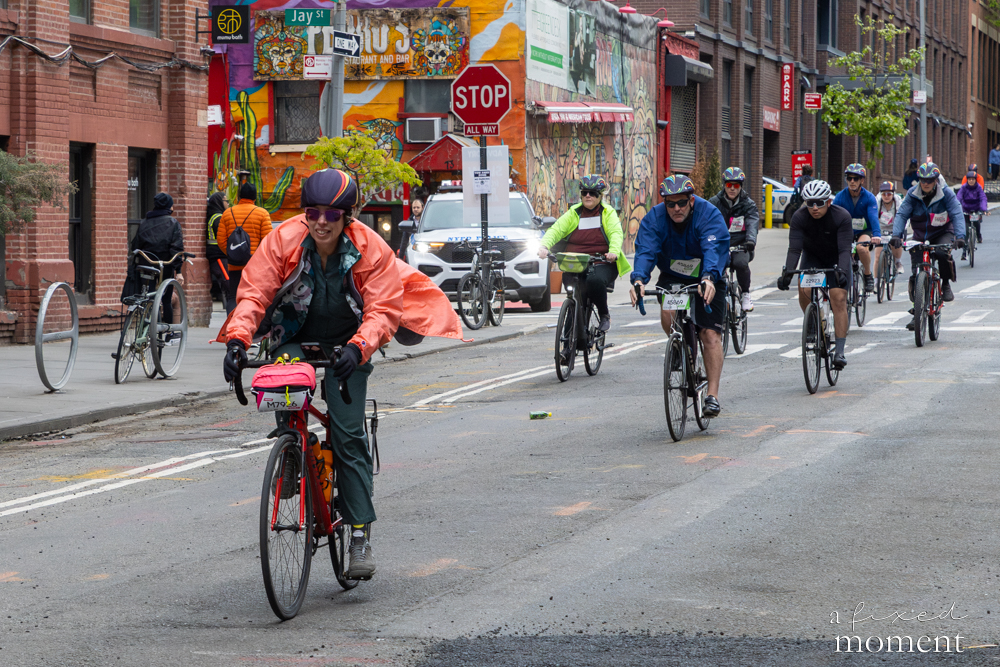 Cyclists pass a street mural in Brooklyn during the 2026 Five Boro Bike Tour