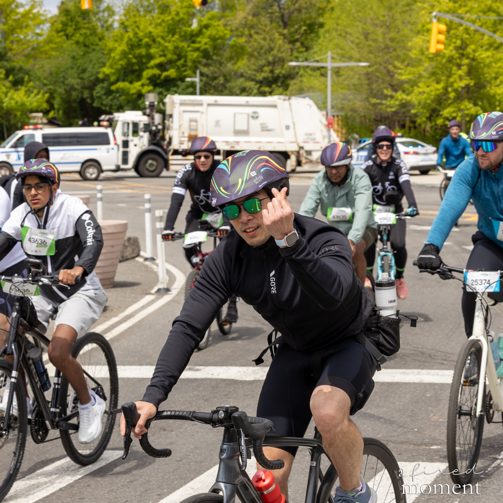 Cyclist gestures at a group intersection during the 2026 Five Boro Bike Tour