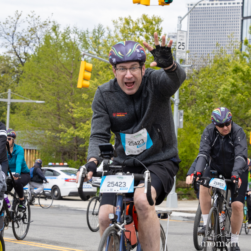 Cyclist reaches toward the camera during the 2026 Five Boro Bike Tour