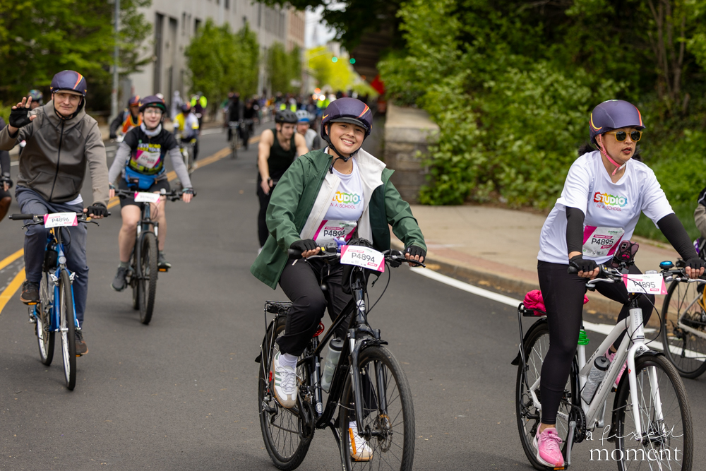 Group of cyclists rides through an urban road during the Five Boro Bike Tour